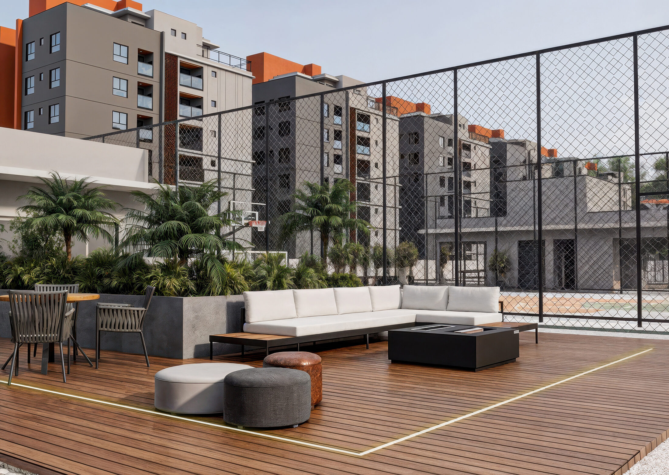 Lounge ao ar livre do Zaya com deck, sofás e quadra, e as torres residenciais ao fundo — Penha/SC